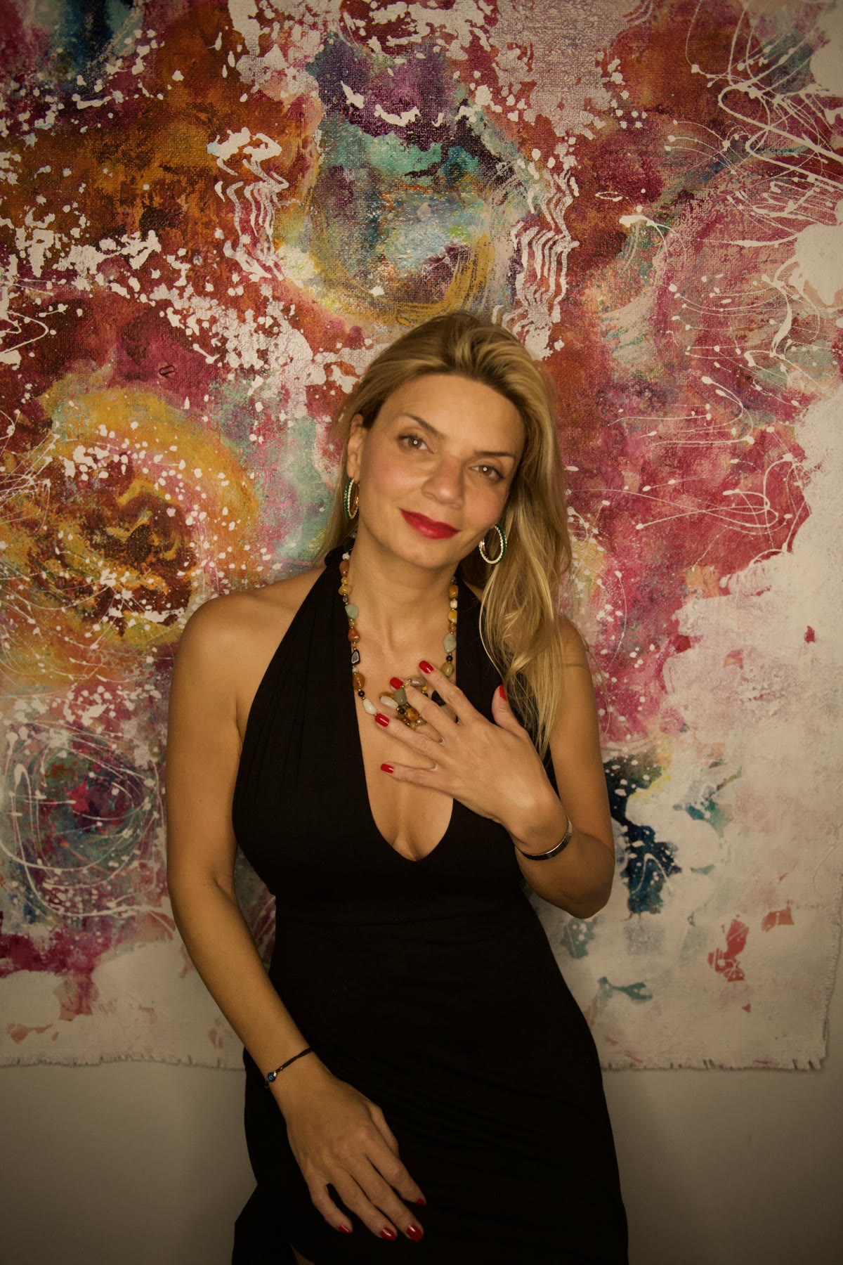 Polen Cerci in front of a large pink and violet work