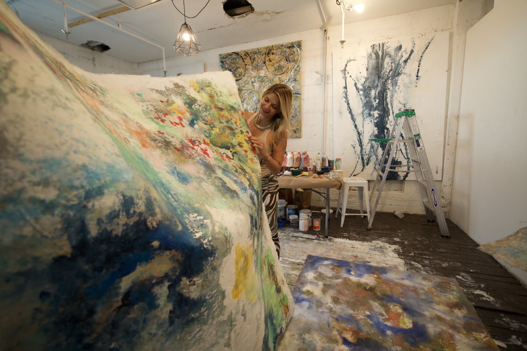 Polen Cerci behind a large burlap work in motion
